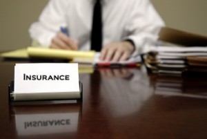 Man sitting at desk with files and insurance business card