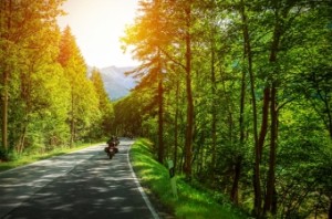 Biker on mountainous road in sunset light, motorcyclist on highway, drive motorbike along Alps, Euro